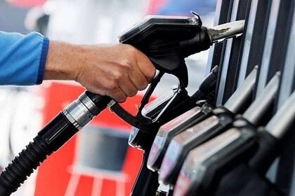 Benzin pompasına dokunan el, yakıt doldurma istasyonunda yakıt pompası.